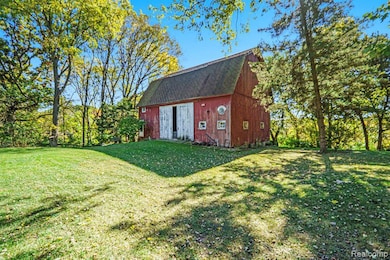 View of grassy yard with a barn and an outdoor structure