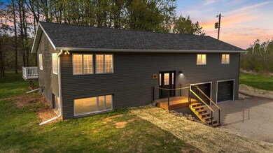View of front of home featuring driveway, a wooden deck, a lawn, an attached garage, and a shingled roof