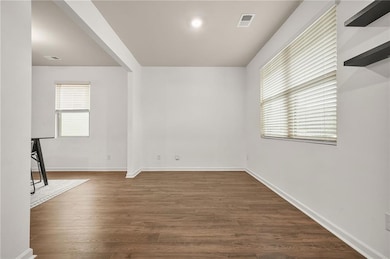 Spare room with dark wood-type flooring and plenty of natural light