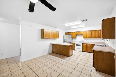 Kitchen featuring a peninsula, light countertops, white electric range oven, and light tile patterned floors