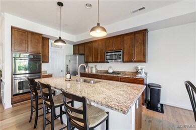 Kitchen featuring a center island with sink, hangi