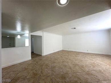 Spare room with a textured ceiling and light tile patterned flooring