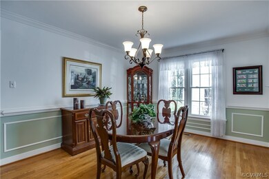 Dining Room with crown molding, chair rail, and pi