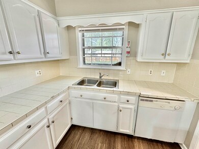 Kitchen with white dishwasher, tile countertops, w