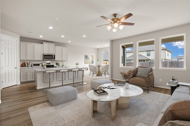 Gather the family and guests together in your lovely living room! Featuring high ceilings, recessed lighting, dark stained ceiling fan, custom paint, gorgeous floors, and large windows that provide plenty of natural lighting throughout the day.
