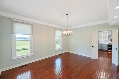 Unfurnished dining area with ornamental molding, dark wood-style floors, a chandelier, and recessed lighting