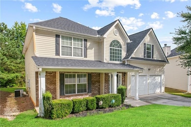 Traditional home featuring concrete driveway, covered porch, a front lawn, roof with shingles, and brick siding