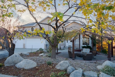 View of front of home with a garage, a patio area, stone siding, driveway, and outdoor lounge area