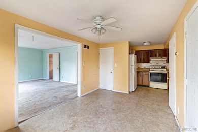 Kitchen with white appliances, tasteful backsplash, open floor plan, ceiling fan, and under cabinet range hood