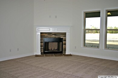 Nice corner fireplace with stone surround and custom site-built mantle in large famiy room