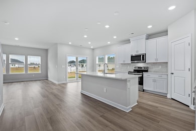 Kitchen featuring white cabinetry, stainless steel