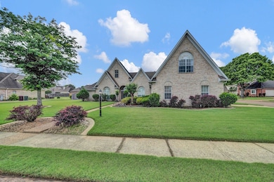 French country home featuring a front yard and brick siding