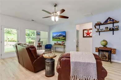 Living room with light wood-type flooring and a ceiling fan