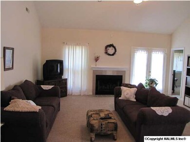 Great room has wood burning fireplace, ceiling fan, vaulted ceiling, carpet, window covering to remain.
