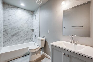 Full bathroom featuring toilet, vanity, and tiled 
