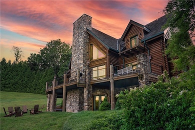 Back house at dusk with a lawn and a balcony