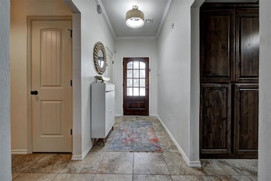 Foyer with ornamental molding and baseboards