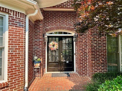 Entrance to property featuring french doors and brick siding