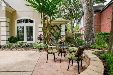 Patio area in the front with the striking landscaping all around this home.