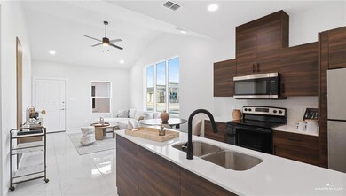 Kitchen featuring lofted ceiling, sink, dark brown cabinets, ceiling fan, and stainless steel appliances