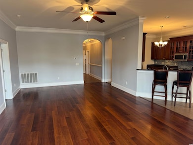 Unfurnished living room featuring ceiling fan with