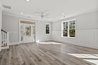 Unfurnished living room featuring ceiling fan, orn