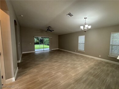 Empty room with arched walkways, a chandelier, a c