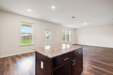 Kitchen featuring dark wood-type flooring, dark b