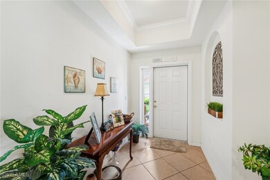 Foyer featuring crown molding, light tile patterne