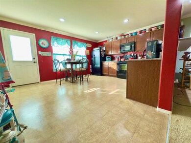 Kitchen with crown molding and black appliances