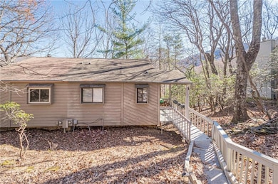 View of side of home with roof with shingles
