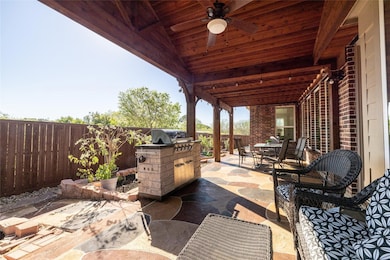 Fenced backyard with a patio, exterior kitchen, outdoor dining space, and ceiling fan