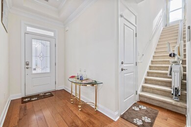 Foyer featuring crown molding and hardwood / wood-style flooring