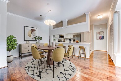 The room seamlessly connects to a modern kitchen with stainless steel appliances, perfect for entertaining.