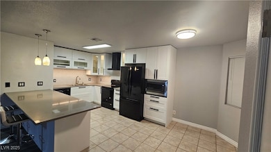Kitchen with black appliances, a Quartz peninsula,