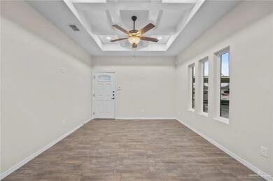 Entryway featuring a raised ceiling, ceiling fan, coffered ceiling, and hardwood / wood-style flooring