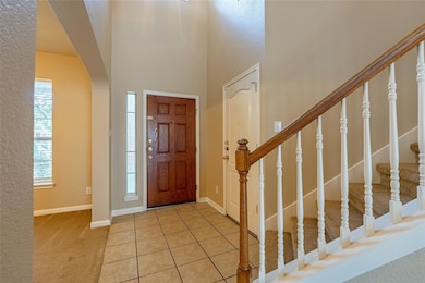 Carpeted foyer entrance with arched walkways, sta