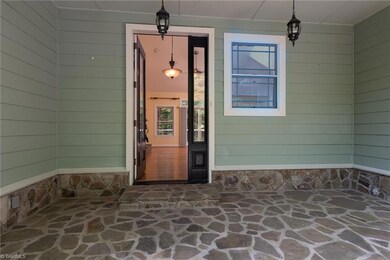 Inviting entrance with stone covered porch