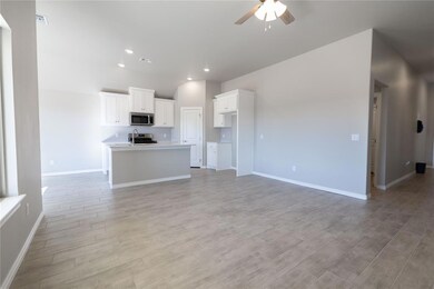 Unfurnished living room featuring ceiling fan and 