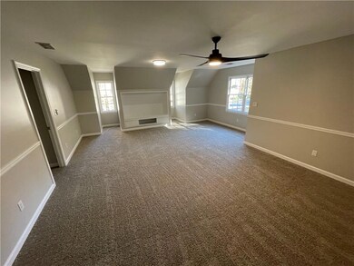Bonus room featuring carpet, lofted ceiling, and a ceiling fan