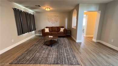 Living room with arched walkways, wood finished fl