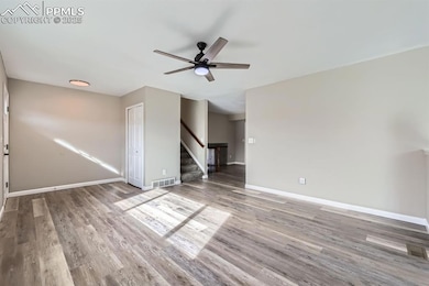 Spare room with wood-type flooring and ceiling fan