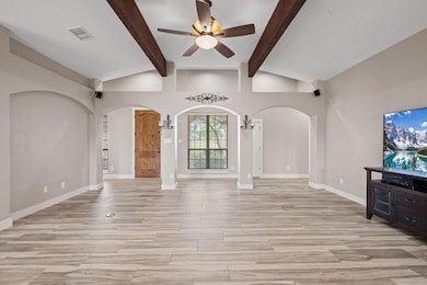 Unfurnished living room with arched walkways, cei