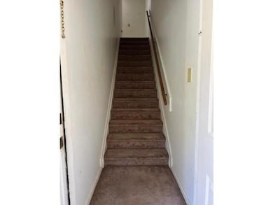 Stairway featuring baseboards and carpet