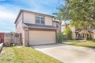 View of property featuring a garage and a front lawn