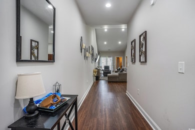 Corridor with wood finished floors, baseboards, and recessed lighting