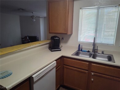 Kitchen with white dishwasher, light countertops,