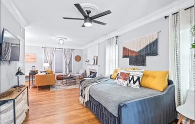 Bedroom with crown molding, ceiling fan, and wood-
