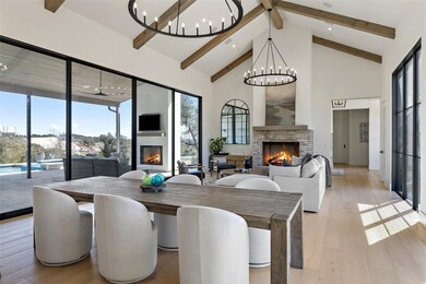 Dining room with a lit fireplace, a chandelier, b