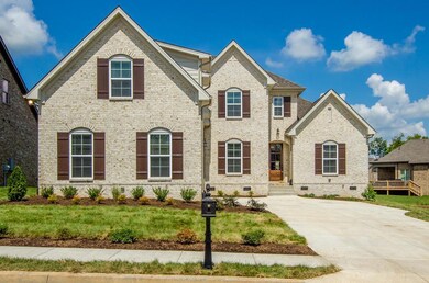 Mostly Brick Exterior with courtyard driveway and side entry 2 car garage. These are not actual pictures of home under construction